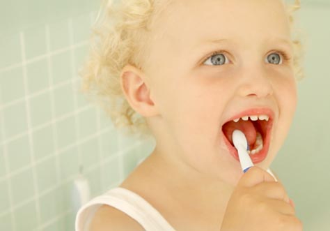 [Translate to romanian:] kid cleaning teeth